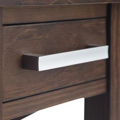 a close up of a wooden drawer with white handles