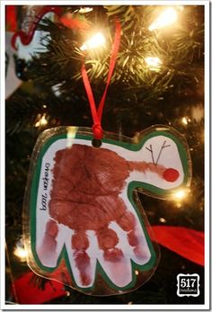 a handprint ornament hanging from a christmas tree