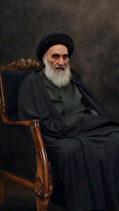 an old man sitting in a chair with a long white beard and wearing a black hat