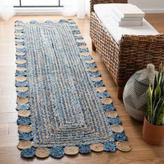 a blue rug with circles on it next to a basket and potted plant in front of a window