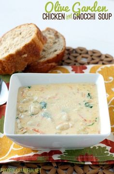 a bowl of chicken and gnocchi soup on a colorful place mat with bread