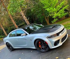 a silver car parked in front of some trees