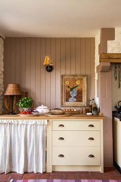 a kitchen with a painting on the wall next to a counter and cabinets in front of it