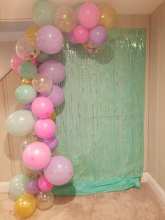 a bunch of balloons that are in front of a curtain on the floor next to a wall