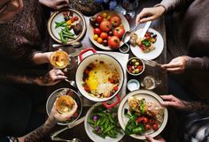 people sitting at a table with plates of food