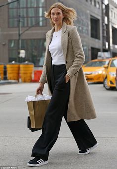 She's learned from the best: Karlie Kloss gave a lesson in off-duty dressing as she headed to a fashion meeting in a pair of wide-legged trousers teamed with trainers in New York City on Wednesday Looks Adidas, Mode Mantel, Wide Legged Pants, Leg Pants Outfit, Trouser Outfit, Chic Coat, Wide Trousers