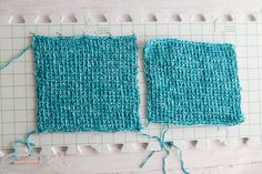 two pieces of blue yarn sitting on top of a cutting board next to each other