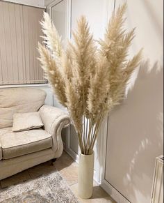 a vase filled with lots of white flowers next to a couch