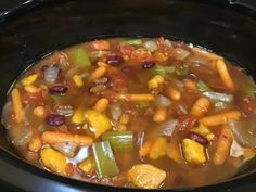 a crock pot filled with soup and vegetables