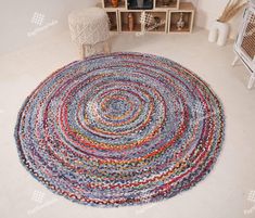 a multicolored round rug on the floor next to a chair and shelf with vases