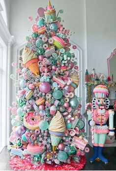 a colorful christmas tree decorated with lots of different types of ornaments and decorating items