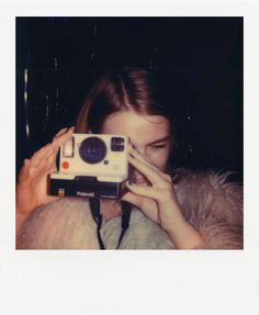 a woman taking a photo with an old polaroid camera