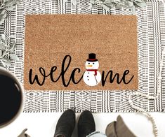 a welcome mat with a snowman on it and the words welcome written in black