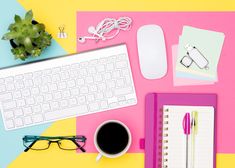 an overhead view of a computer keyboard, glasses, notebook and other office supplies on a colorful background