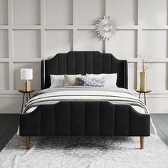 a black bed with white sheets and pillows