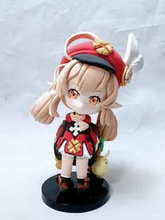 an anime figurine is posed on a white background, wearing a red and black outfit