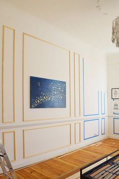 an empty room with blue and white stripes painted on the wall next to a ladder