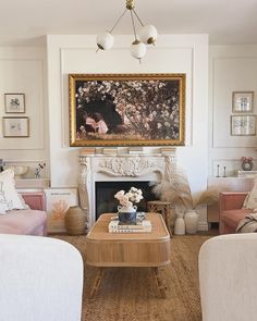 a living room filled with furniture and a painting on the wall above a fire place