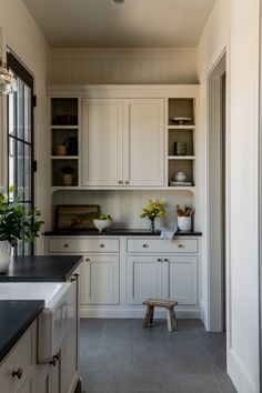 a kitchen with white cabinets and black counter tops