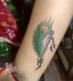 a peacock feather on the arm with an instrument in it's beak and tail