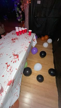 the table is covered with blood and plastic cups for an event or birthday party that needs to be finished