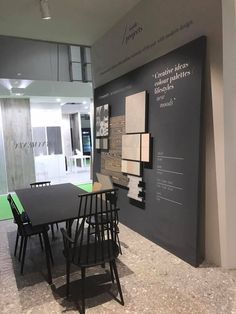 a table and chairs in front of a wall display