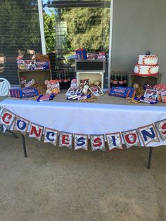 a baseball themed table is set up with cake and confetti on the table