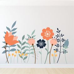 a wall with flowers painted on it and some leaves in the middle, next to a wooden floor