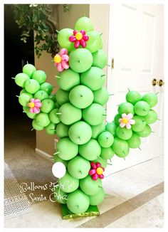 a green balloon sculpture with flowers on it