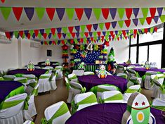 a room filled with lots of tables covered in purple, green and white cloths