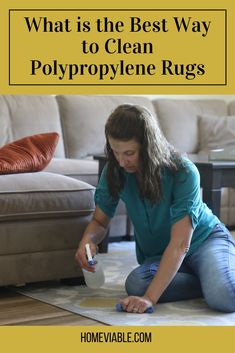 a woman sitting on the floor cleaning her rug