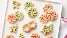 a white plate topped with cookies covered in frosting and sprinkles on top of a table