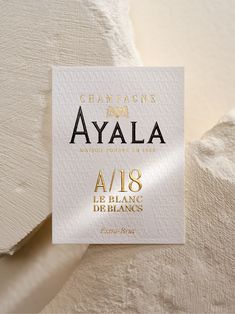 a white business card with gold foil on it that reads champagne for avala,