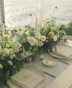 the table is set with white flowers and candles