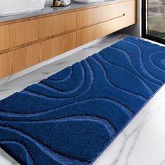 a blue rug on the floor in a bathroom