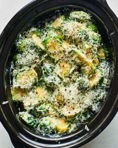 an overhead view of broccoli and cheese in a crock pot on a table