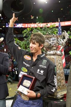 a man holding up a trophy in front of a crowd