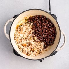 beans and rice are mixed together in a pot on the stove top, ready to be cooked