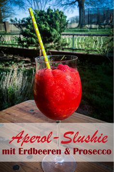 a red drink sitting on top of a wooden table