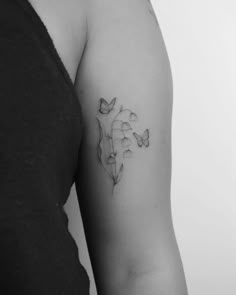 black and white photo of a woman's arm with a flower tattoo on it