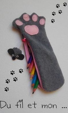 a pencil case with a cat paw and dog's paw on the side, next to it are colored pencils