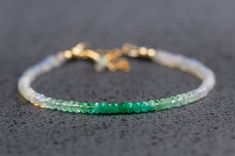 Emerald, Ethiopian opal, silver/gold-filled/14k gold. Length: 6.5 inches, and 1.5 inches chain extender. Bead diameter: 3mm Gorgeous ombre emerald and Ethiopian opal bracelet.  Made with high-quality facet emerald rondelle beads, smooth Ethiopian opal rondelle beads, 1k gold/gold-filled/ sterling silver findings, and Softflex strong beading wire. The merald color changes gradually from dark green to light green to clear opal with strong fire. The facet cut has added some sparkle to the bracelet under sunshine. It looks great on its own and in combination with other bracelets. It also makes this bracelet a perfect gift for May's birthday.  Feel free to contact me if you would like a similar one with a different bracelet length or any other custom jewelry requests. To shop for more bracelets Ethiopian Opal Rondelle Jewelry Gift, Elegant Green Ethiopian Opal Jewelry, Ombre Green, Green Bracelet, Mother Day Gift, Emerald Bracelet, Ruby Beads, Gold Armband, Emerald Bead