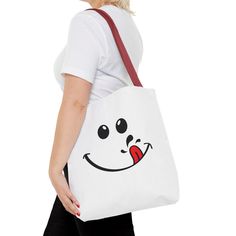 a woman carrying a white tote bag with a smiley face drawn on the side