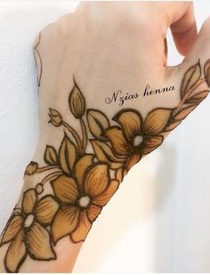 a woman's hand with flowers on it and the words miss henna written in black ink