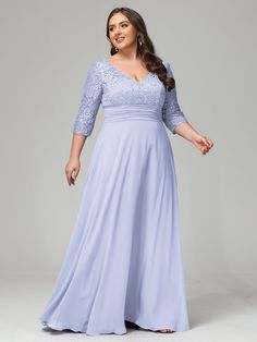 a woman in a long blue dress posing for the camera with her hands on her hips