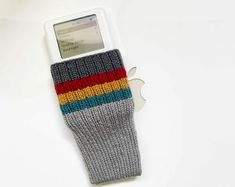 an ipod case is made out of knitted material and sits on a white surface