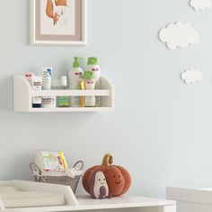 a baby's room with blue walls, white furniture and toys on the shelf