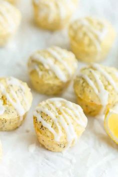 lemon poppy seed muffins with white icing on a sheet of parchment paper