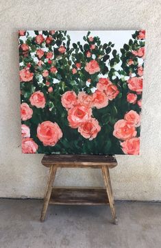 an easel with a painting of pink roses on it