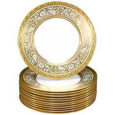 a stack of gold plates sitting on top of each other in front of a white background